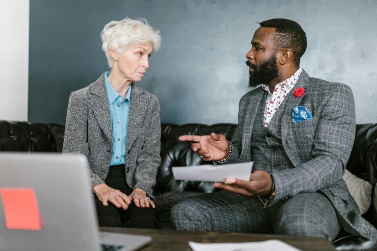 A focused business meeting between two colleagues discussing documents inside a modern office.