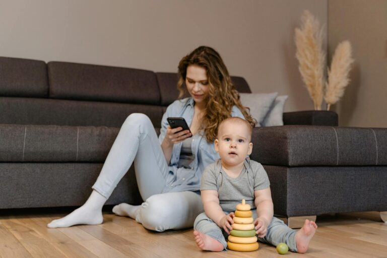 A mother engages with her baby at home, creating a warm family moment.