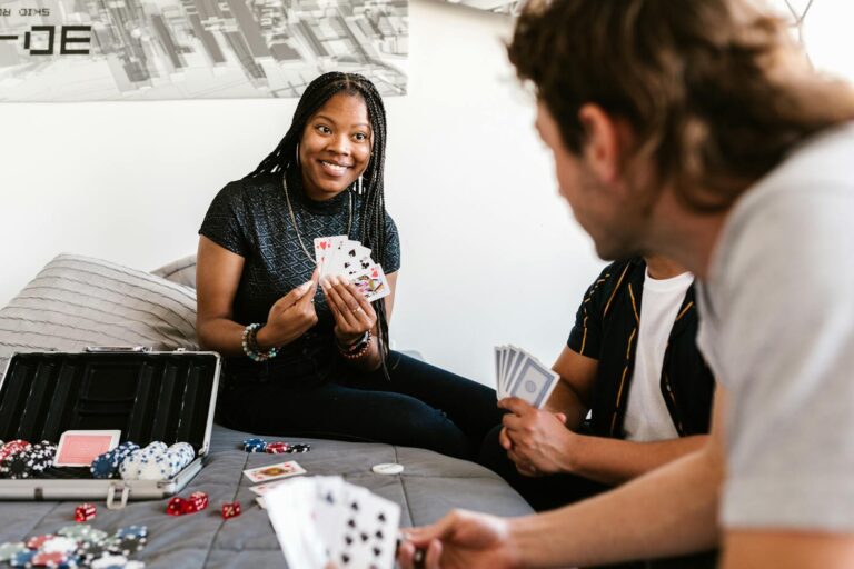 Group of diverse friends enjoying a poker game in a cozy bedroom environment.