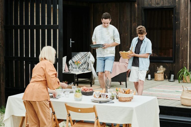 Family members setting up an outdoor table for lunch, creating a cozy atmosphere.