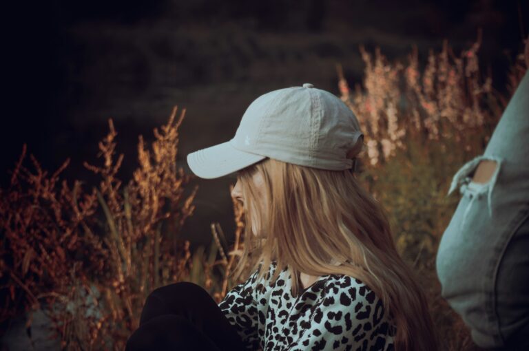 a woman with long blonde hair wearing a white hat