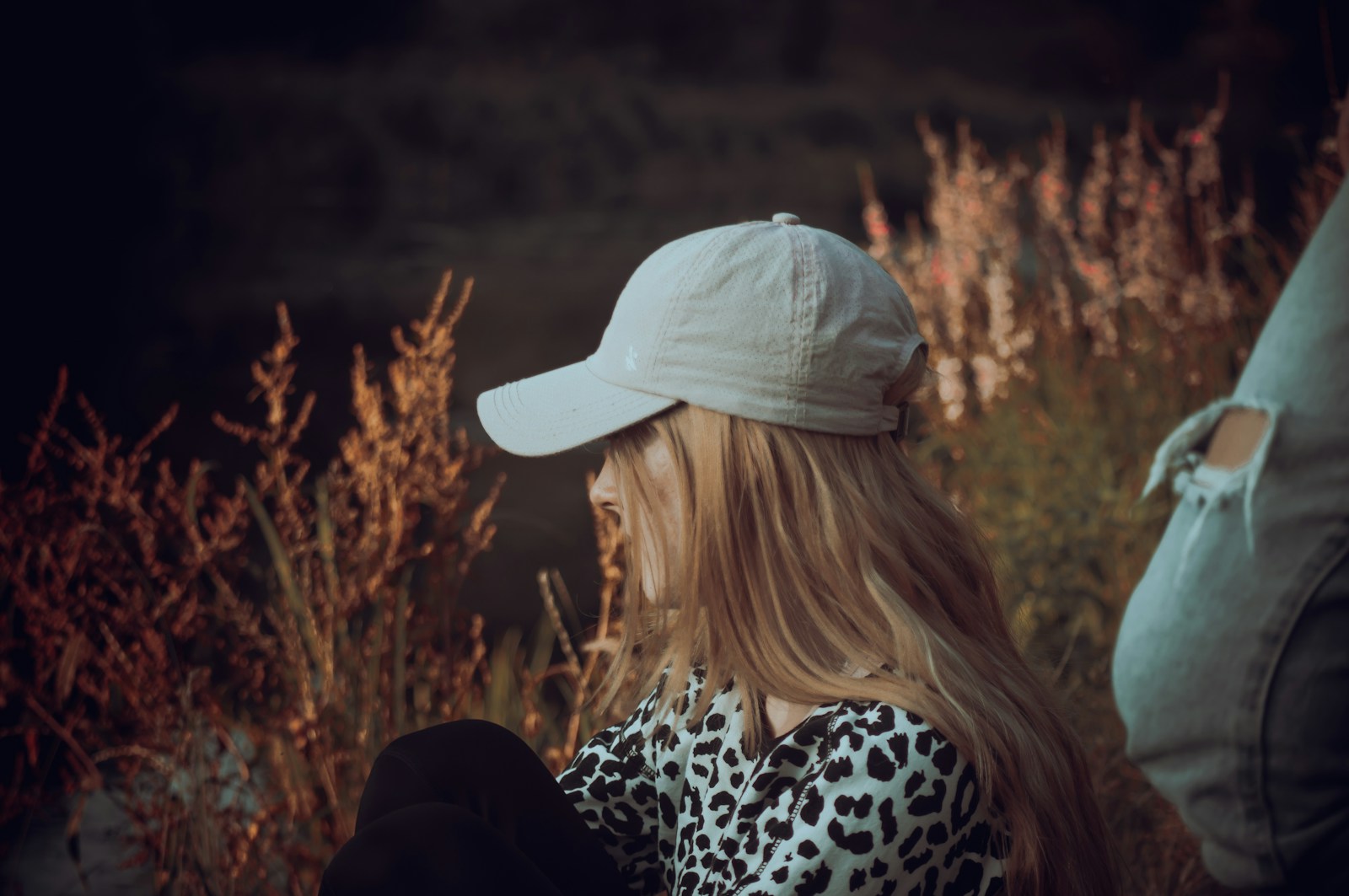 a woman with long blonde hair wearing a white hat