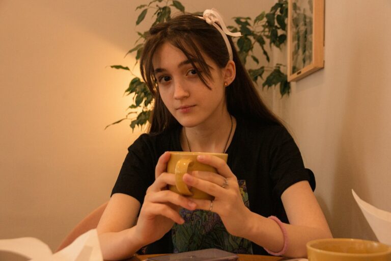 woman in black shirt holding yellow plastic cup