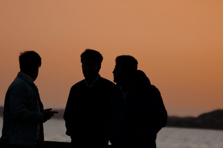 a group of men standing in front of a body of water