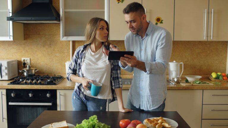 Couple looking at tablet in kitchen