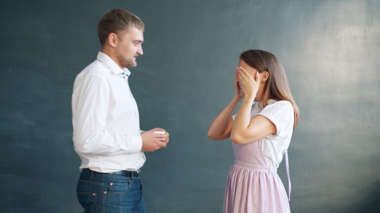 Man offers ring to surprised woman covering eyes