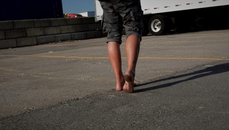 A person standing in front of a semi truck