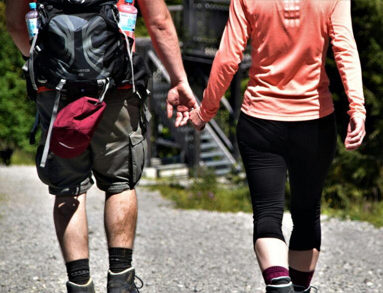 2 men in red shirt and black shorts running on road during daytime