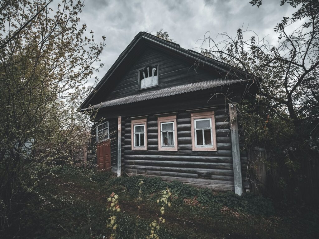 an old wooden house with a clock on the top of it