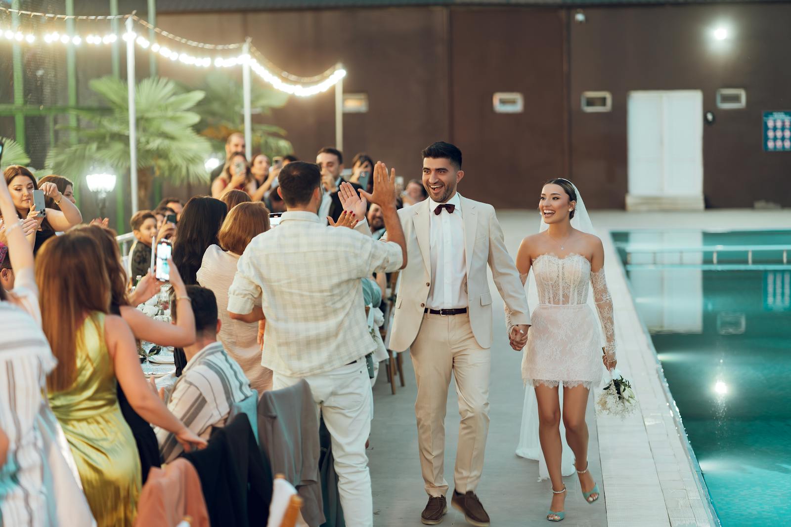 Bride and groom walking down the aisle at an elegant outdoor celebration.