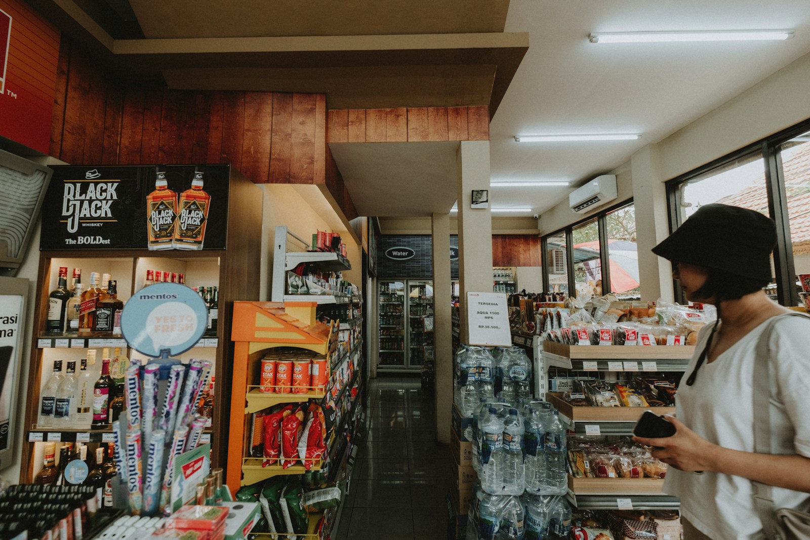 Woman browsing shelves in a convenience store.