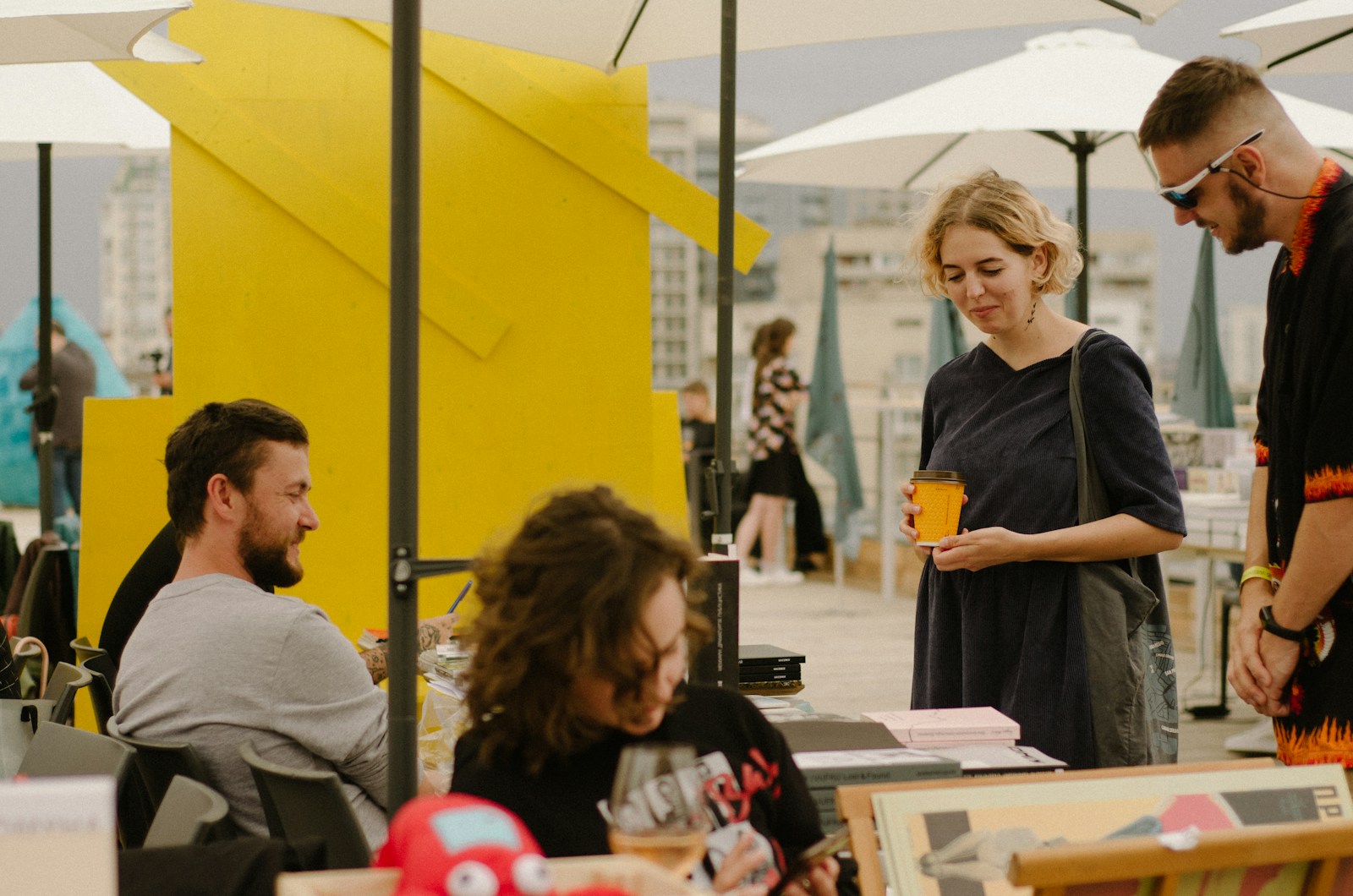 a group of people sitting at tables under umbrellas
