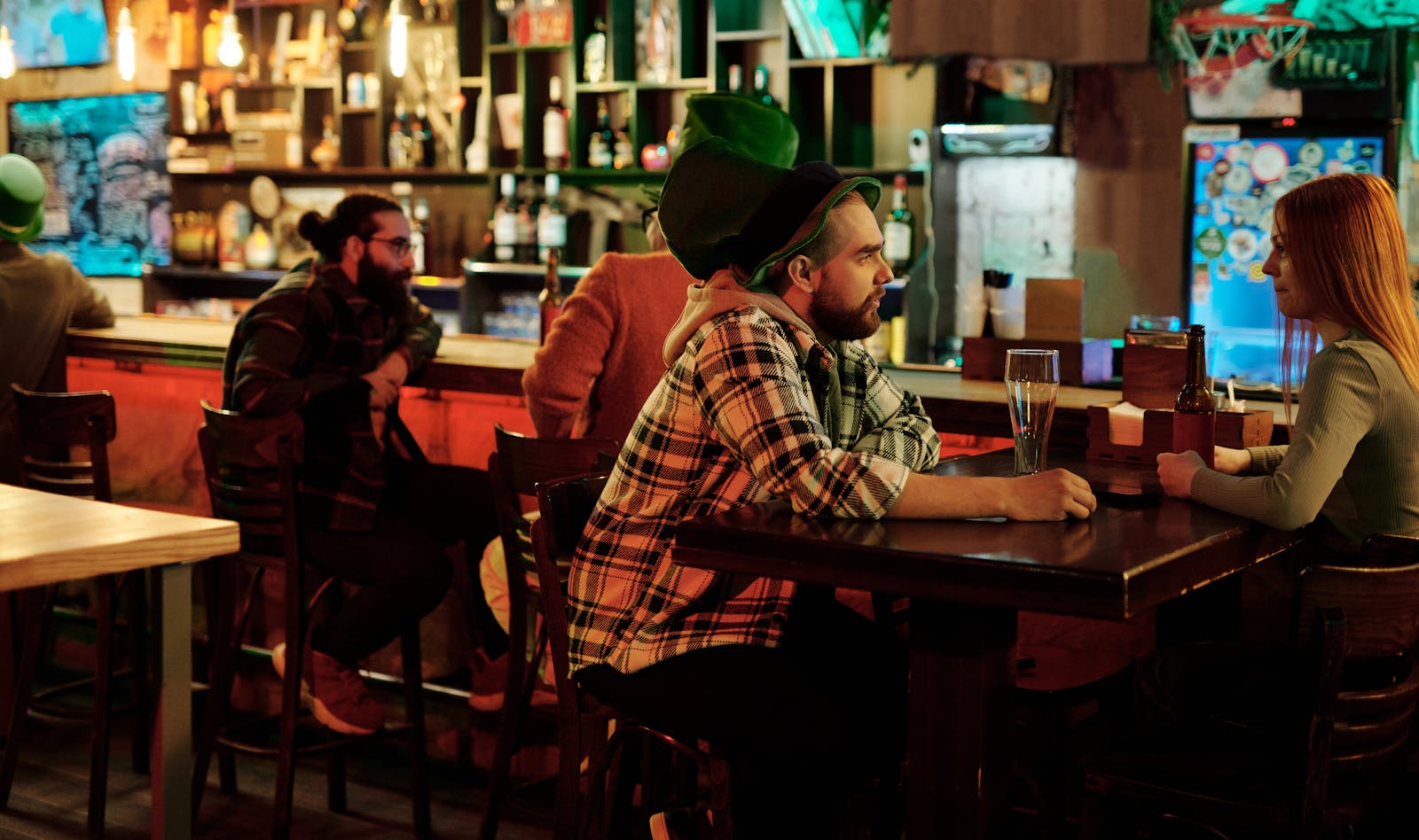 People enjoying drinks at a festive Irish bar setting during Saint Patrick's Day.