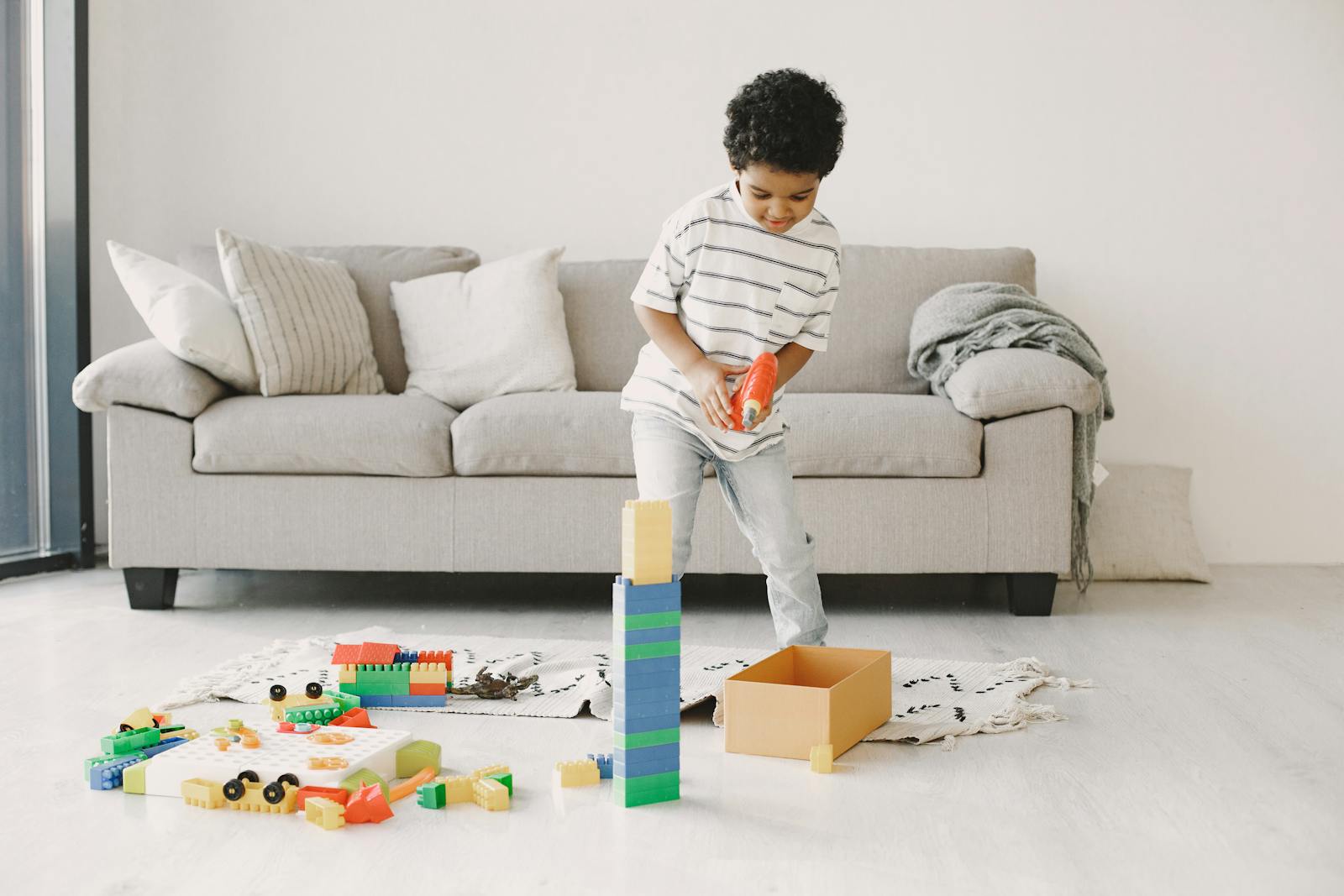 A cheerful child playing with colorful building blocks indoors.