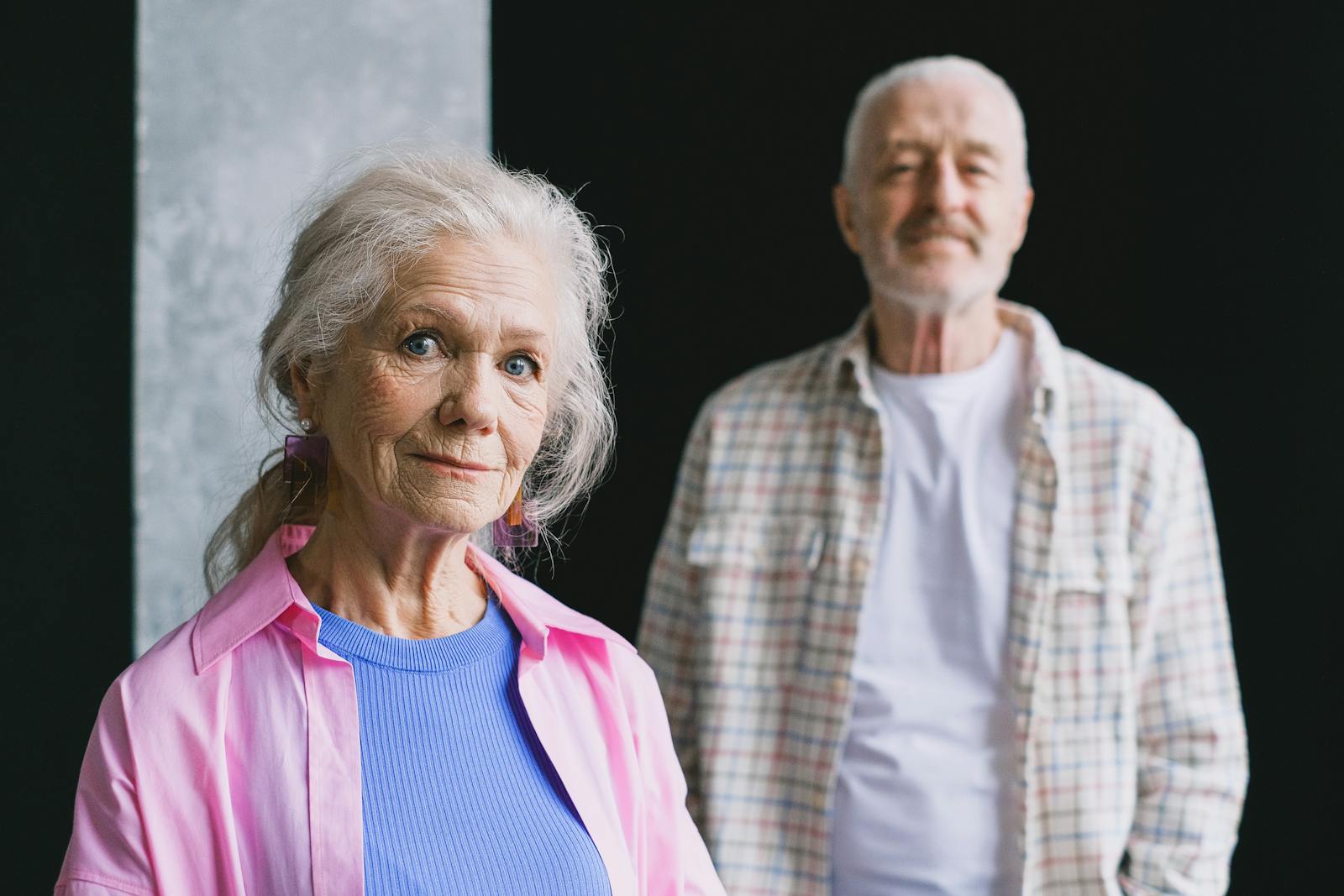 Happy senior couple indoors, warmly smiling and enjoying each other's company.