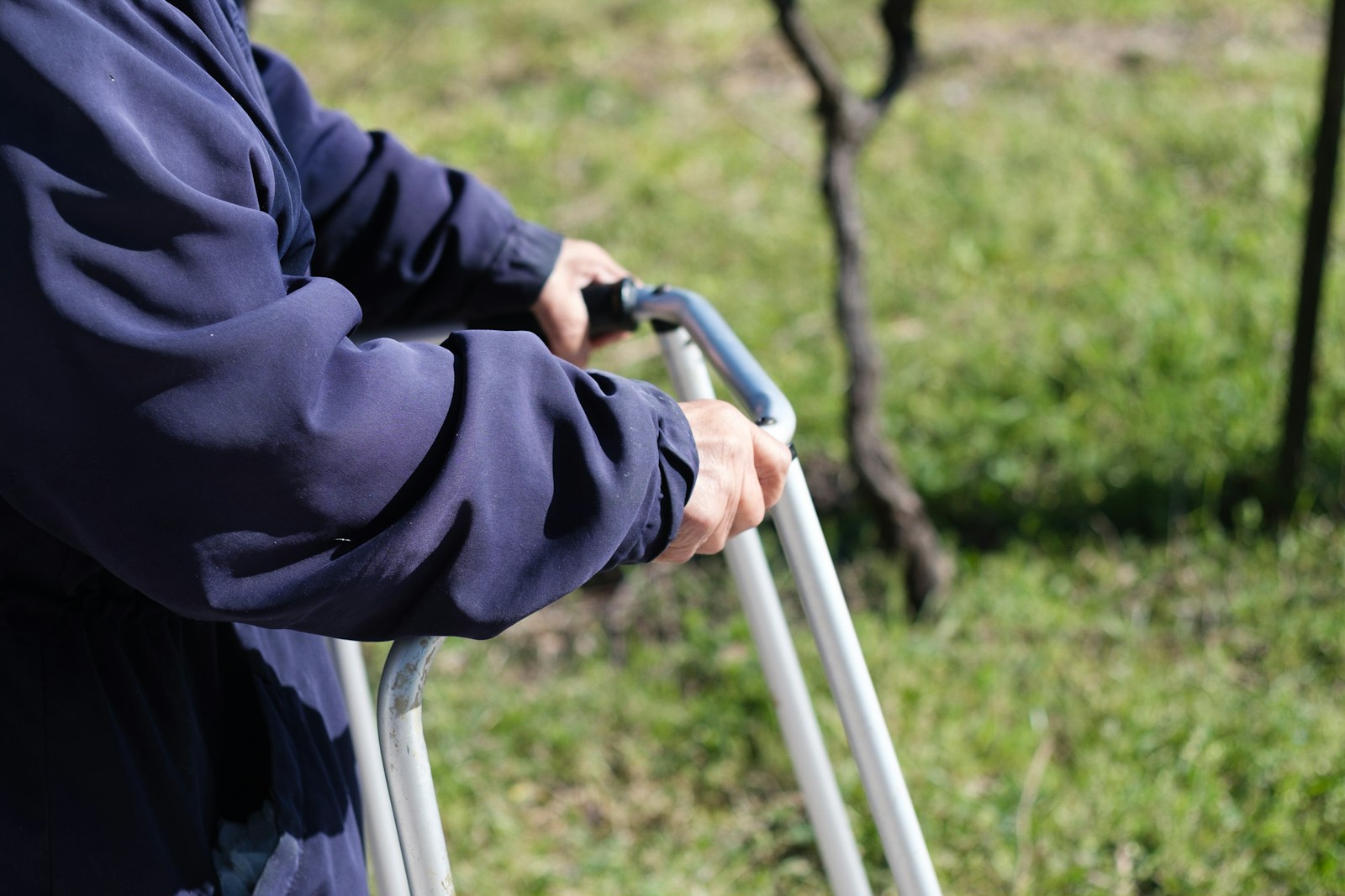 person in black jacket holding on white metal bar