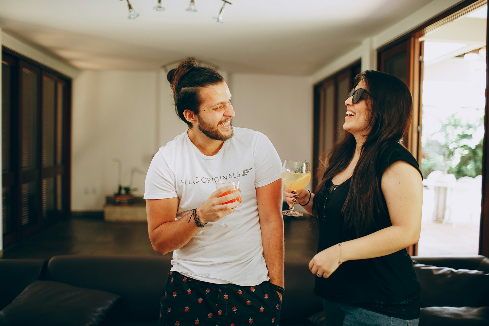 man in white crew neck t-shirt standing beside woman in black and white polka dot