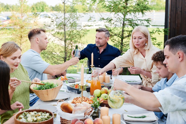 A cheerful family enjoying a delightful outdoor picnic with fresh food and drinks.