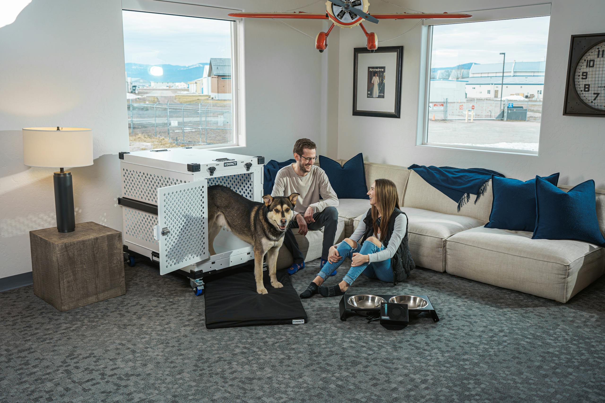 A couple relaxing with their dog in a modern living room setting, emphasizing comfort and pet safety.