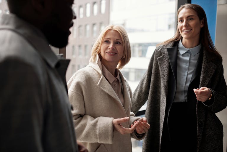 A diverse group of business professionals conversing in an urban office setting.