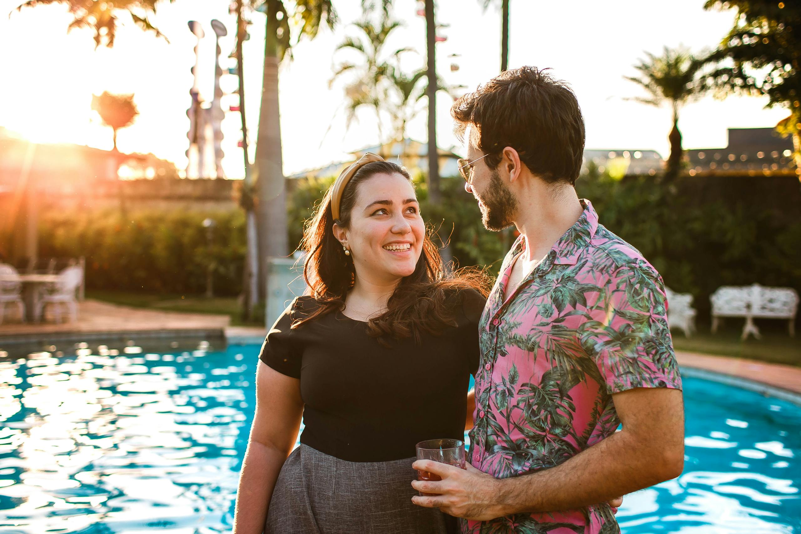A happy couple sharing a moment by the pool during a sunny day, radiating joy and love.