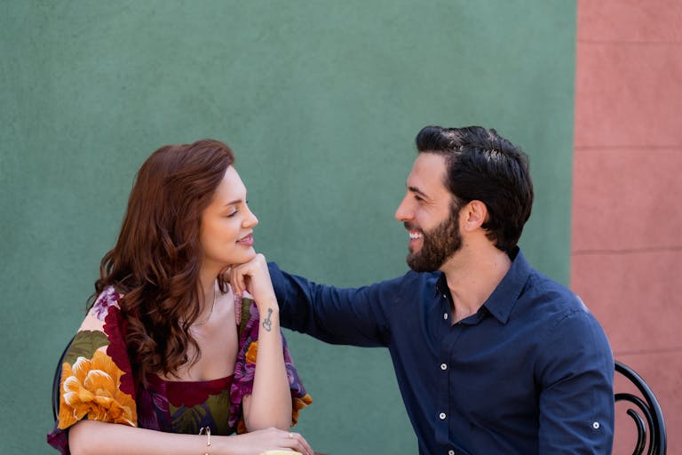 A loving couple smiling at each other outdoors, showcasing affection and happiness.