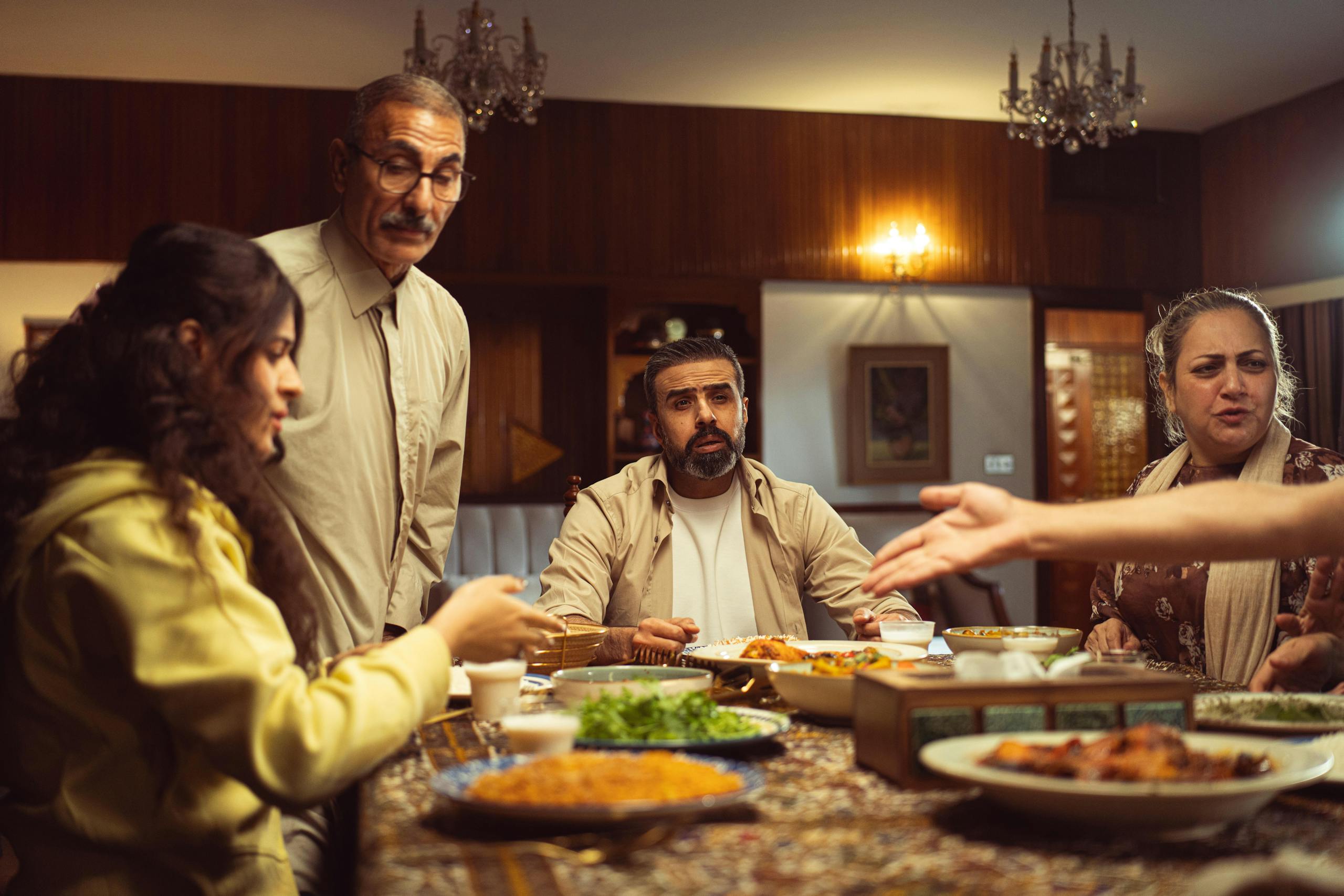 A multi-generational family enjoying a meal together in a warm, inviting indoor setting.