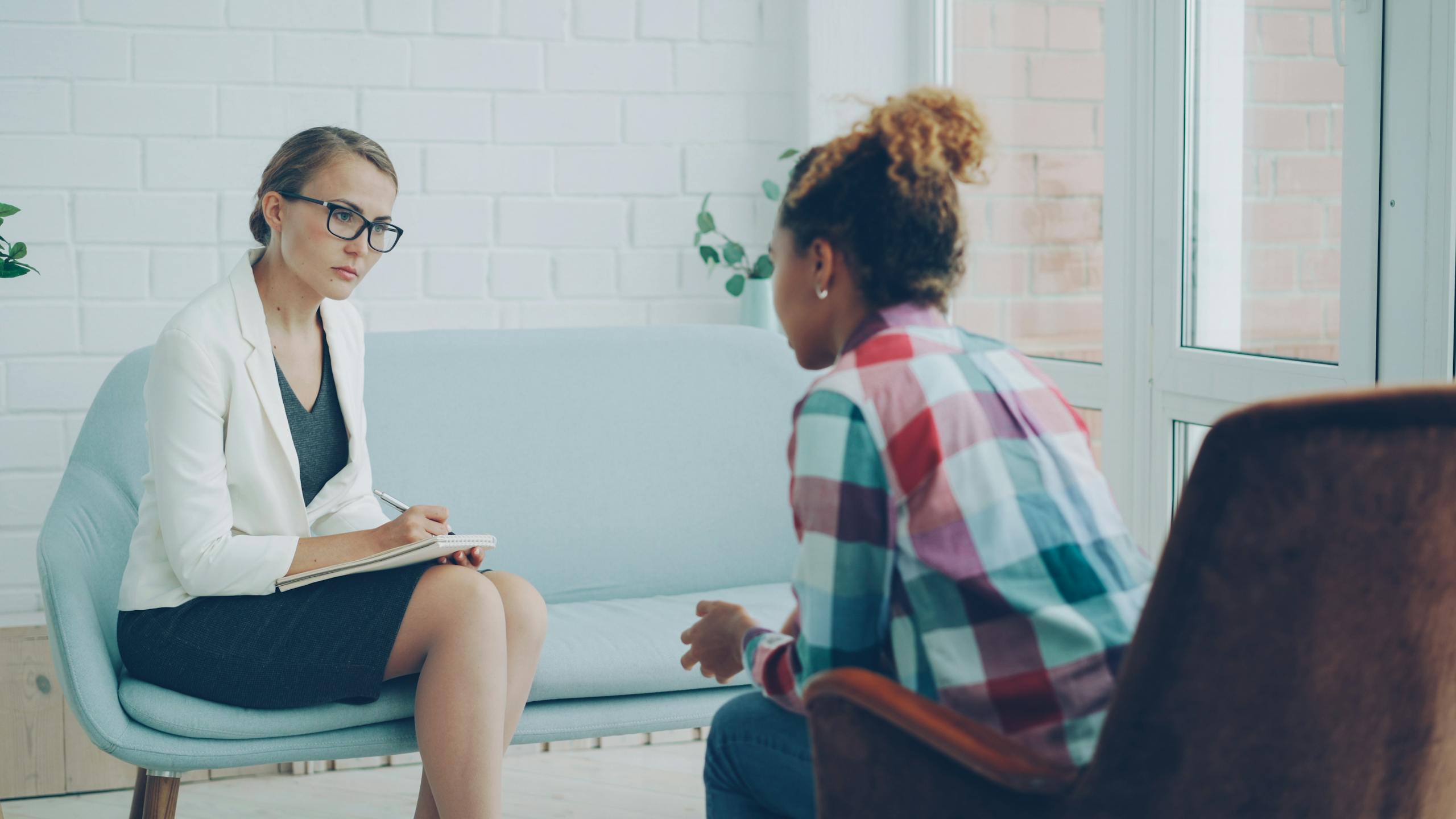 A therapist listens attentively during a private counseling session.
