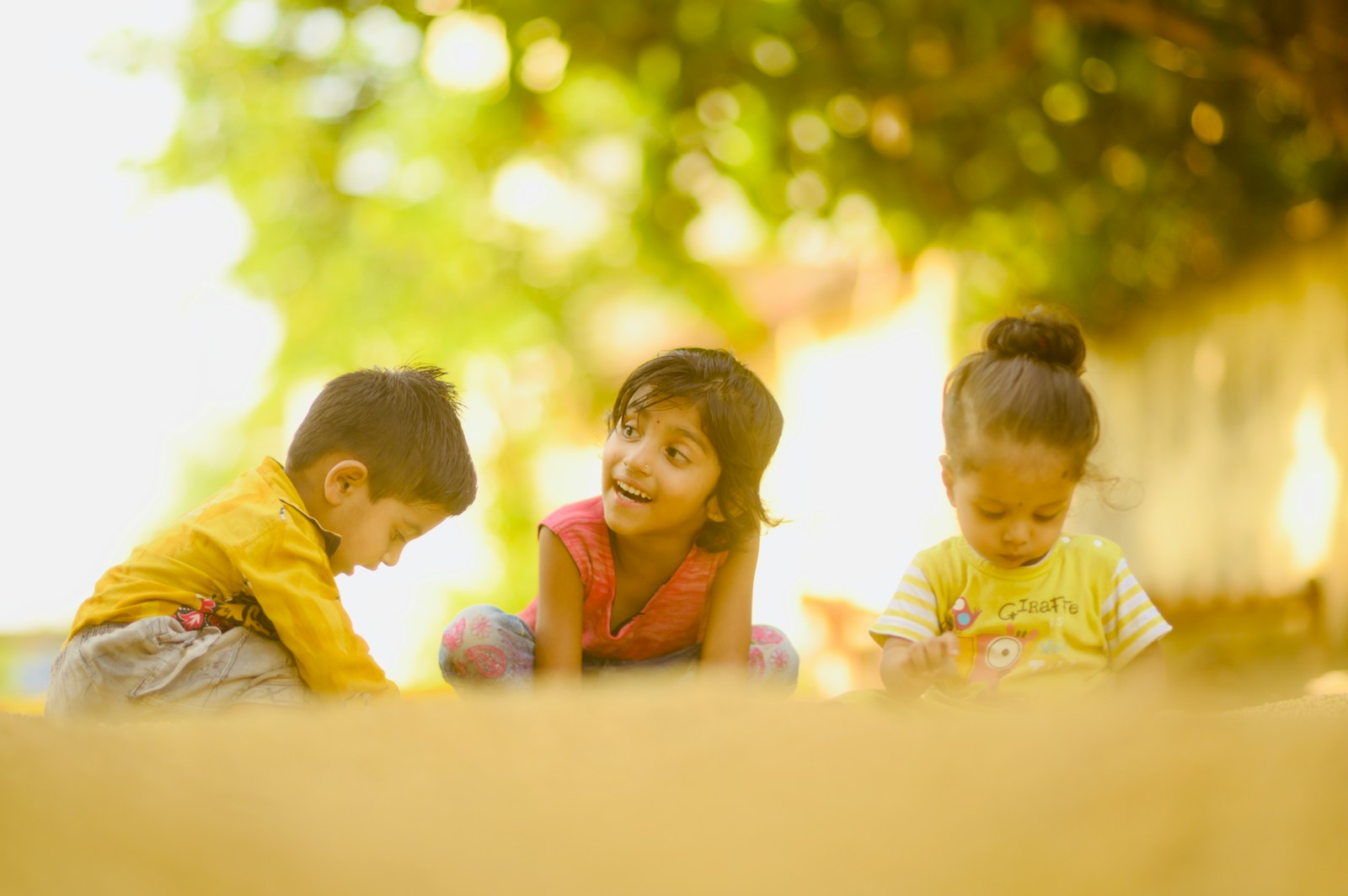 3 children sitting on white table during daytime