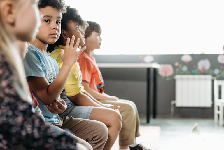 Children of diverse backgrounds sitting in a classroom, capturing innocence and togetherness.