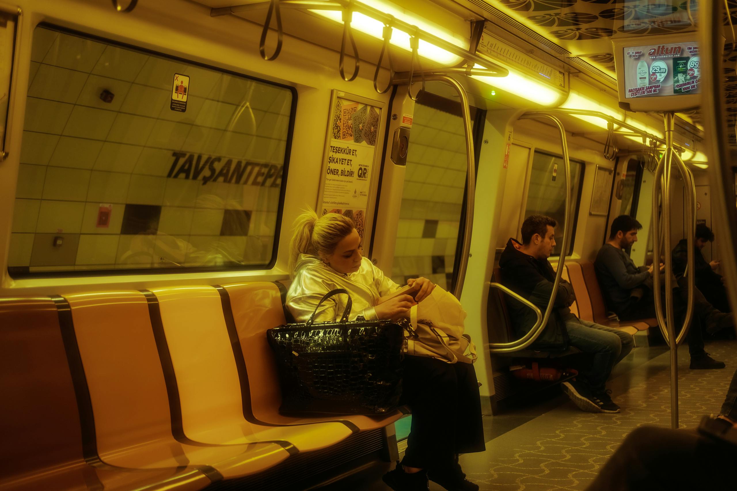 Commuters sitting inside an Istanbul metro train, showcasing a typical urban public transport scene.