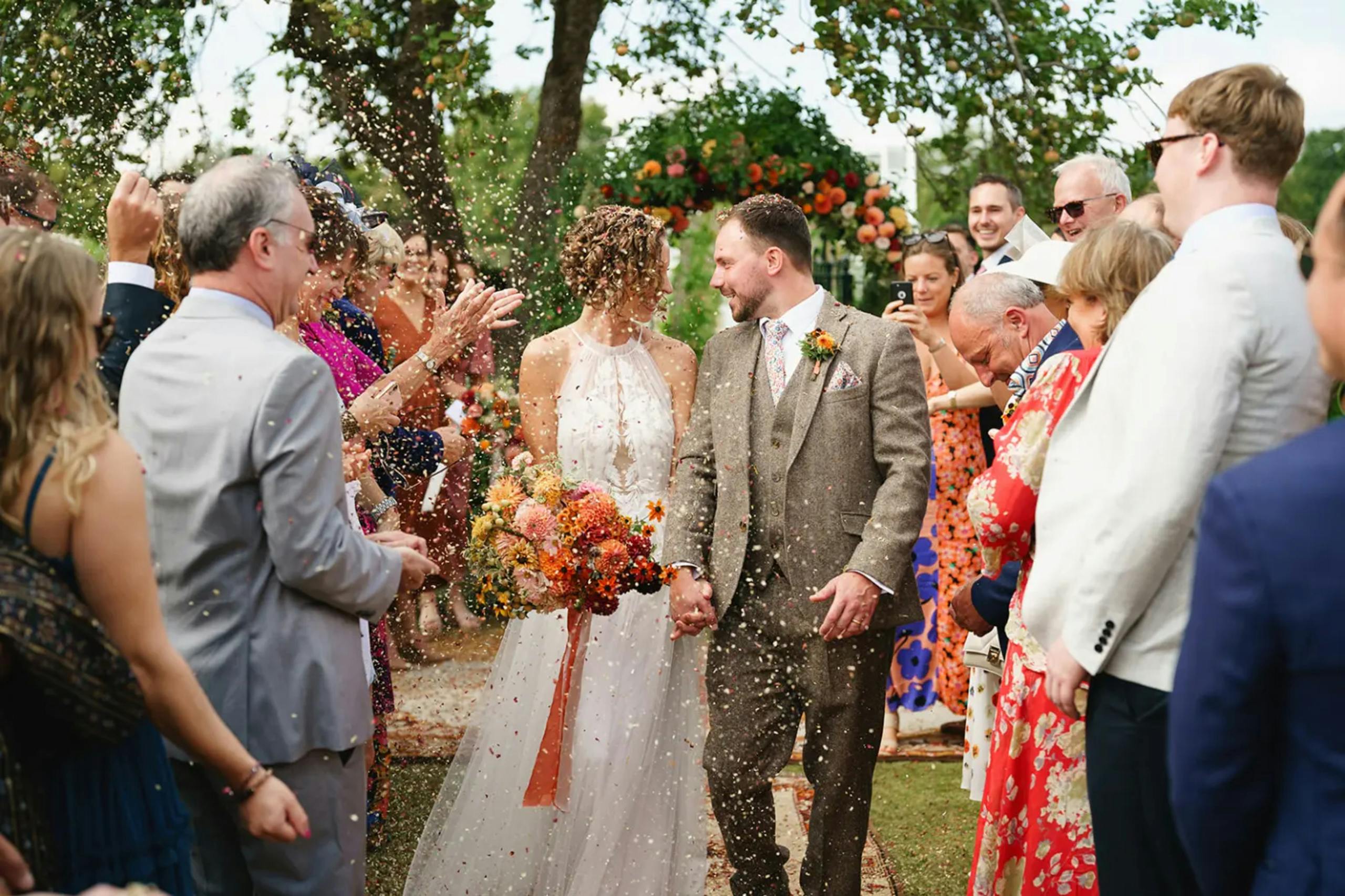 Couple celebrates outdoor wedding in England with family and friends.
