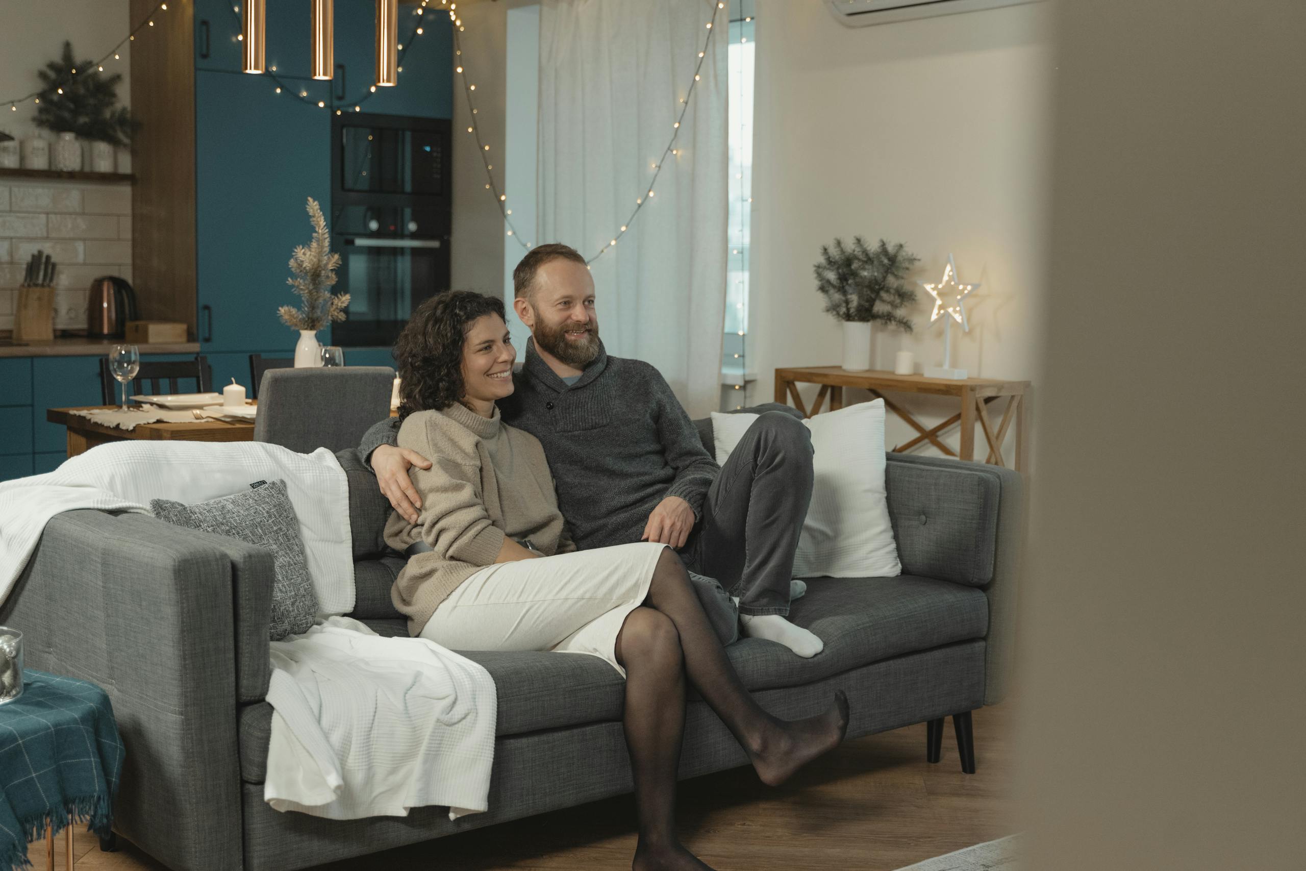 Couple sitting together in a cozy, modern living room, enjoying a relaxing day indoors.