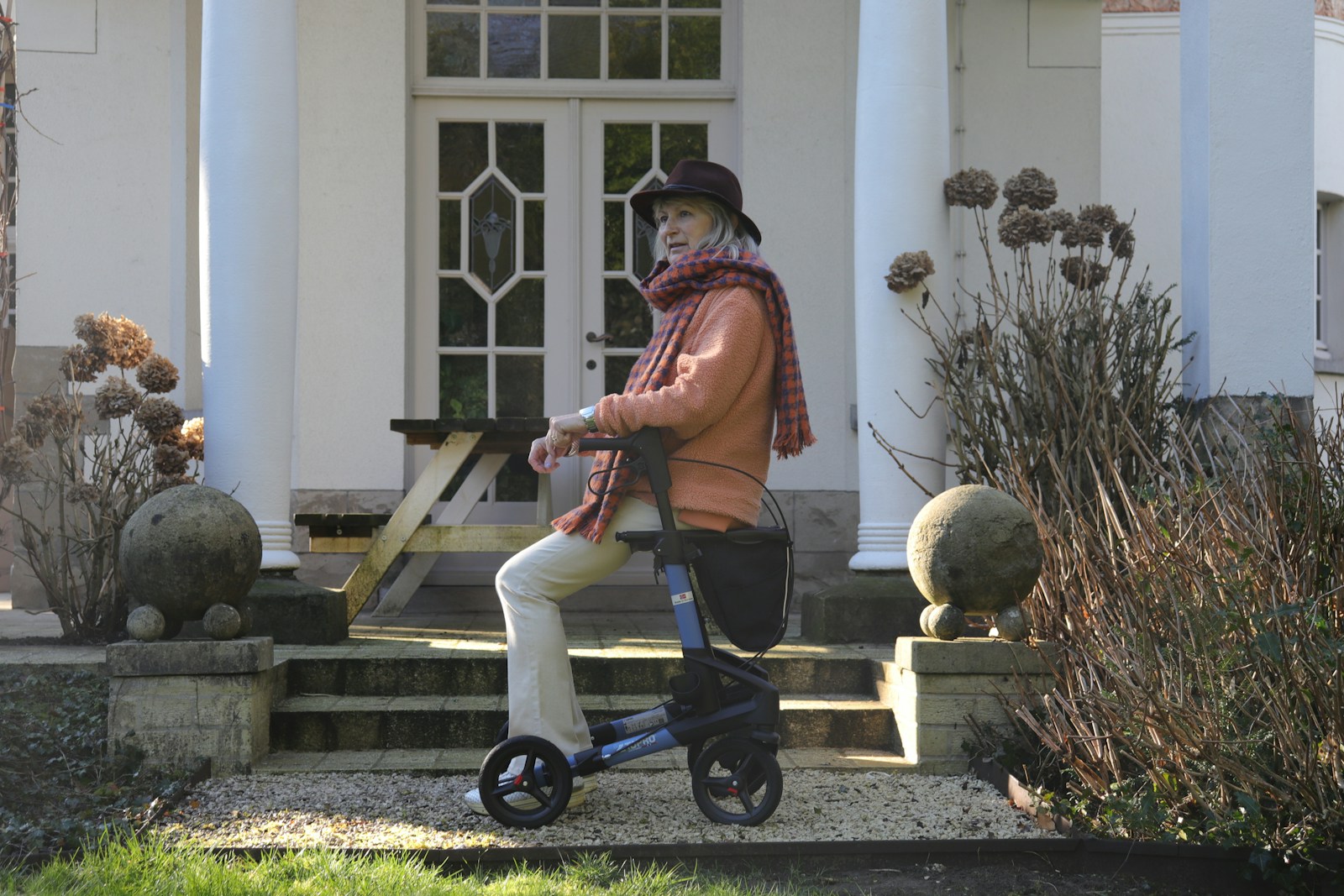 Elderly woman with walker on house steps