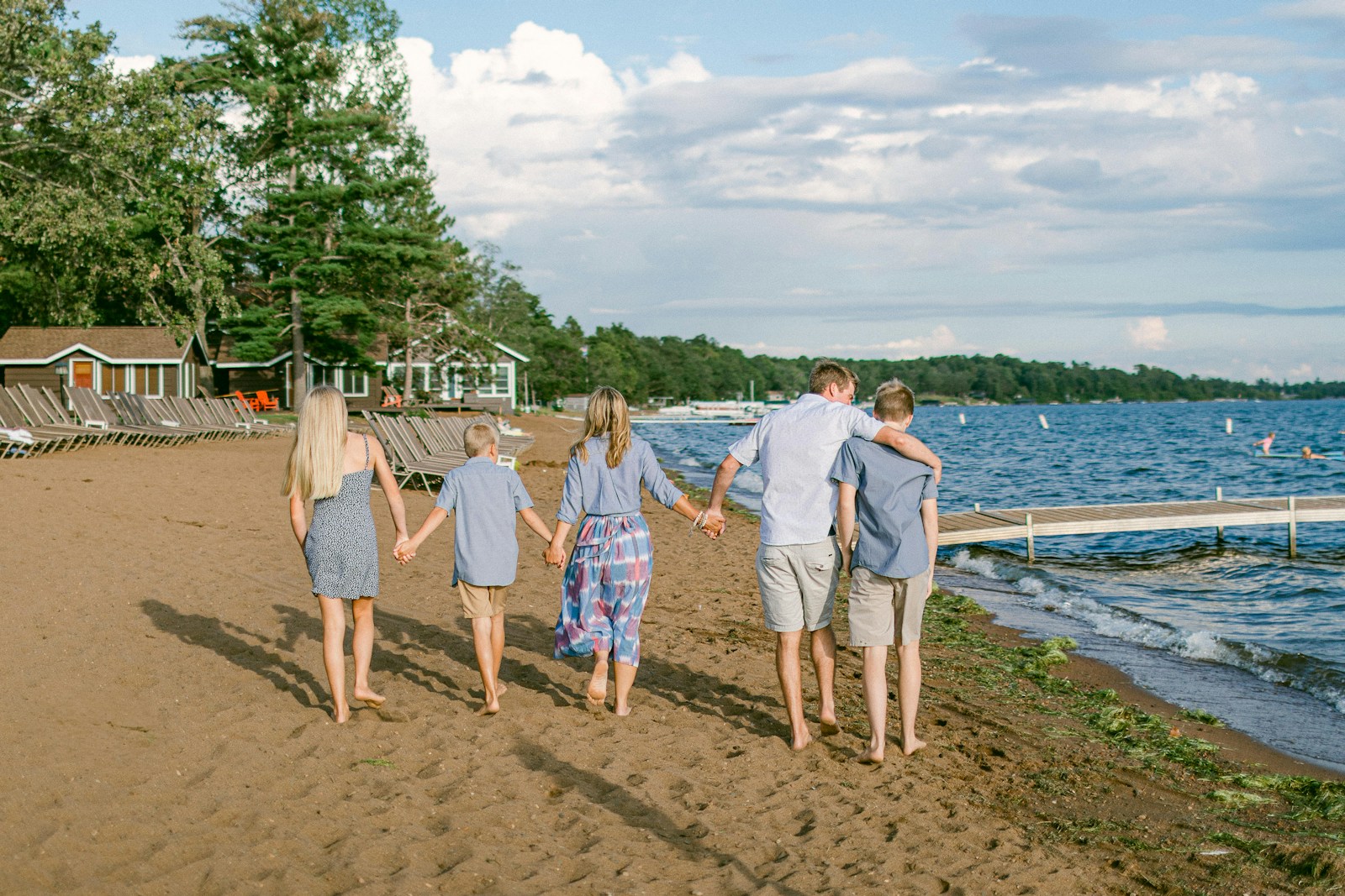 a family walking on the beach holding hands