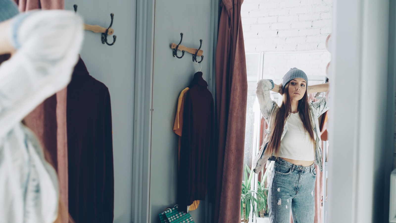 Woman looks at herself in a dressing room mirror.