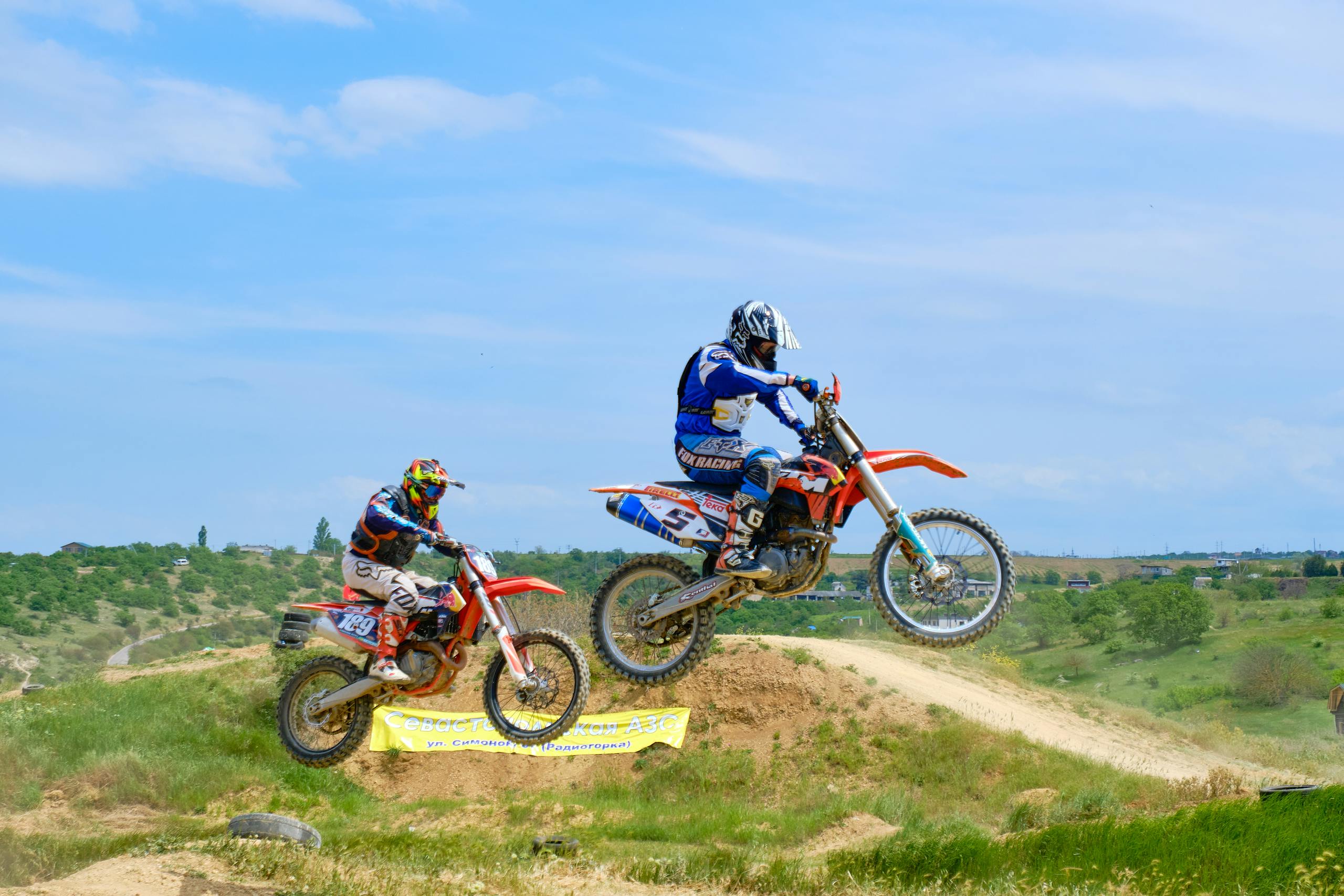 Exciting motocross race with riders airborne on dirt track in Sevastopol, showcasing speed and skill.