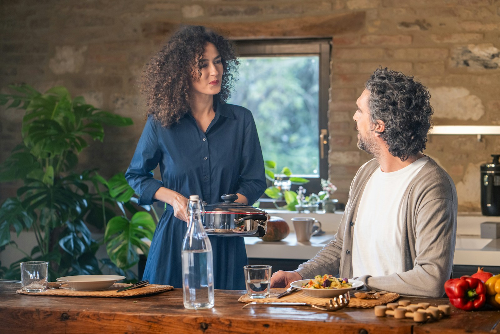 Couple cooking together in a rustic kitchen.