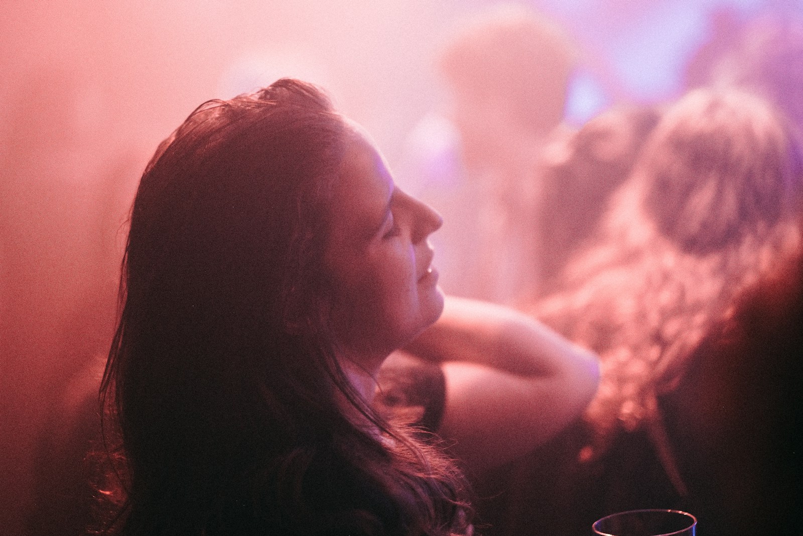 a woman sitting at a table with a drink in front of her
