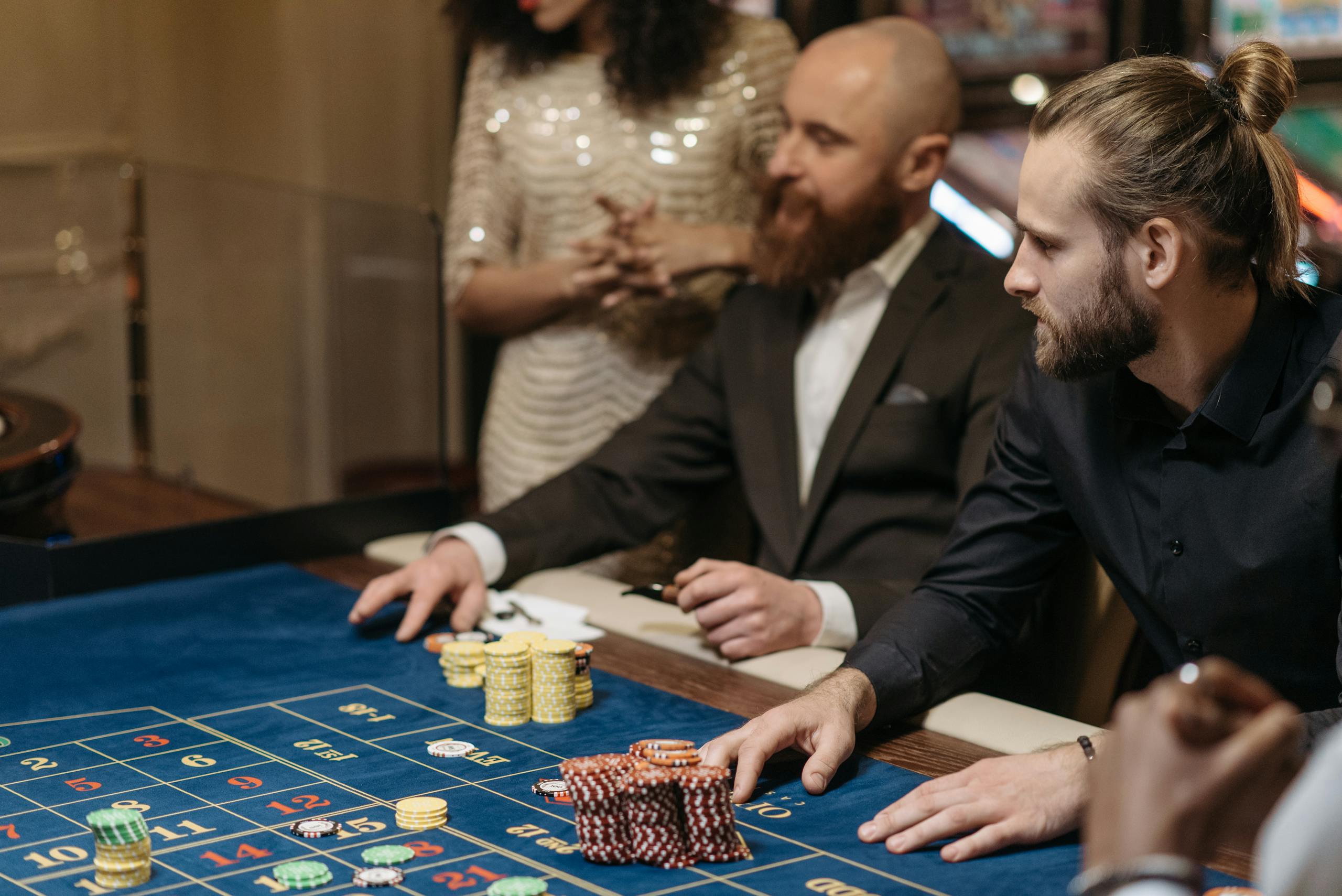 Group of adults enjoying a thrilling roulette game at a casino table.