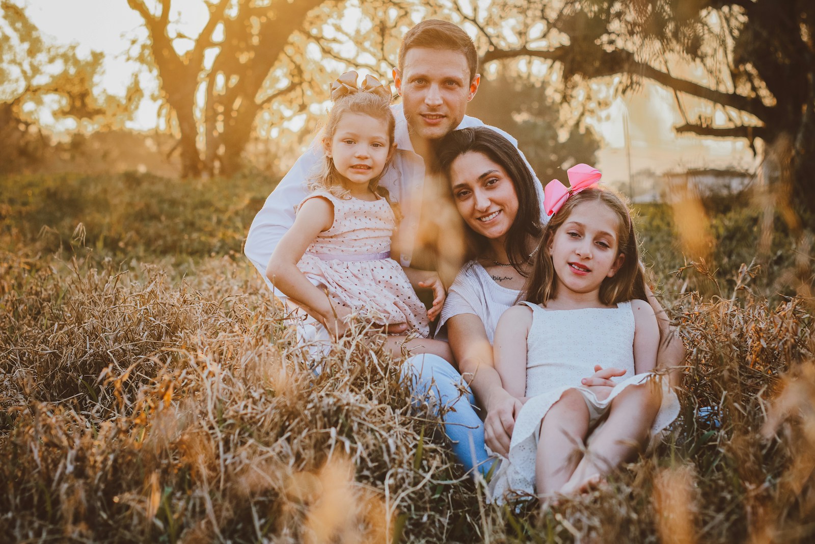 a man and two little girls sitting in a field