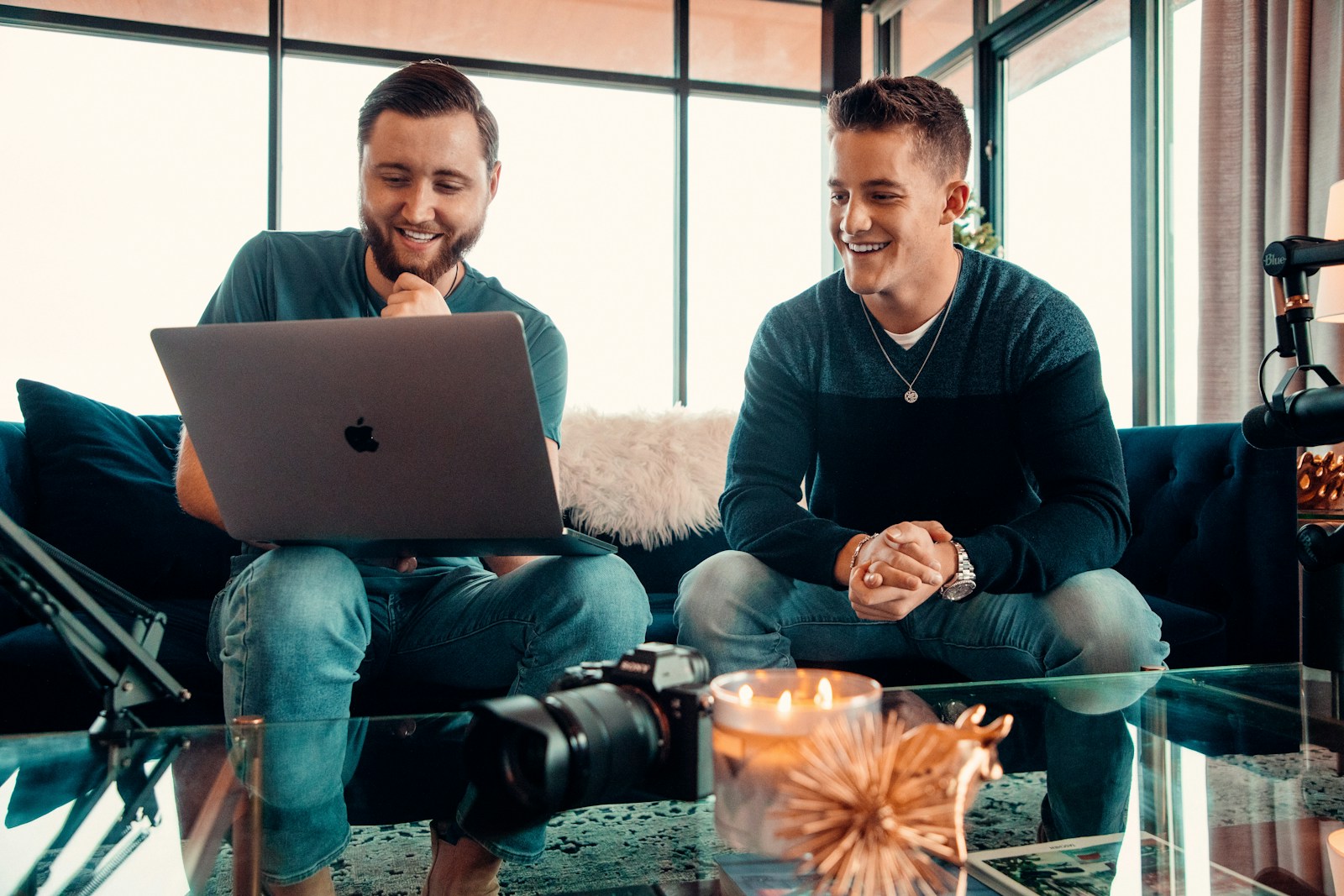 a man and a woman sitting on a couch with a laptop