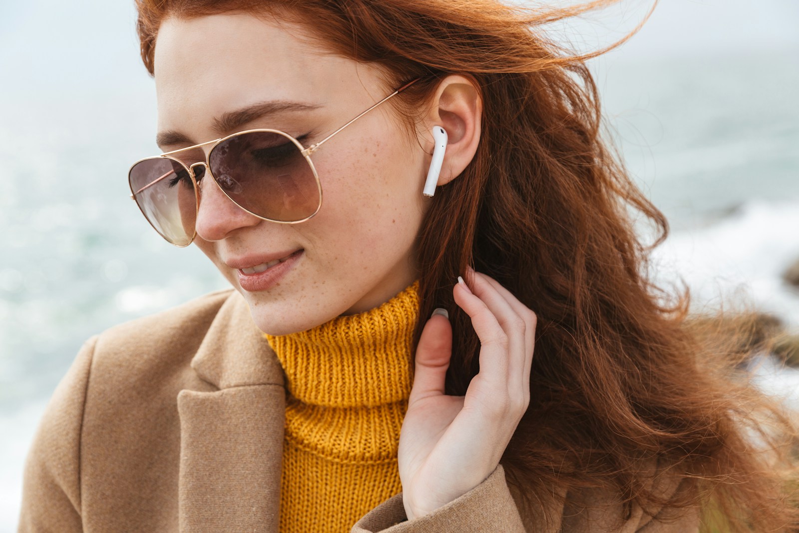 a woman wearing sunglasses and a yellow turtle neck sweater