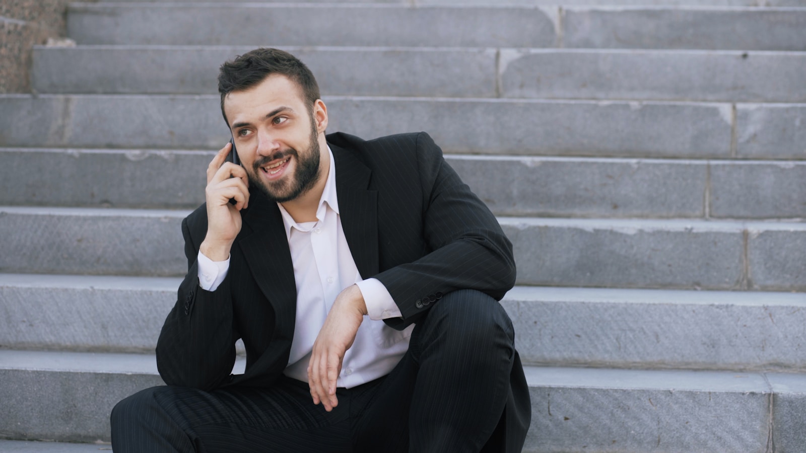 Man in suit talking on cell phone on steps