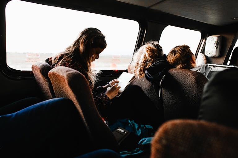 People sitting and reading on a bus, showcasing a relaxed travel experience.