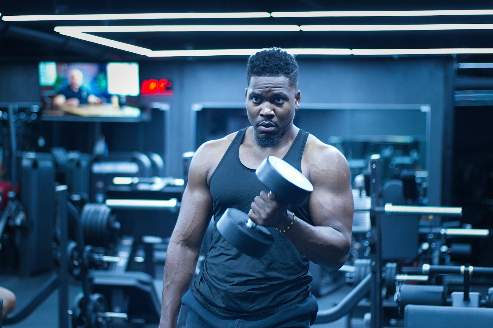 Man lifts a dumbbell in a gym.