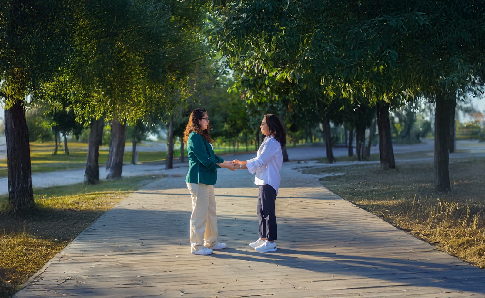 A couple of women standing on top of a sidewalk