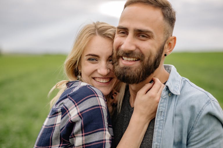 Smiling couple enjoying a loving moment outdoors in nature.