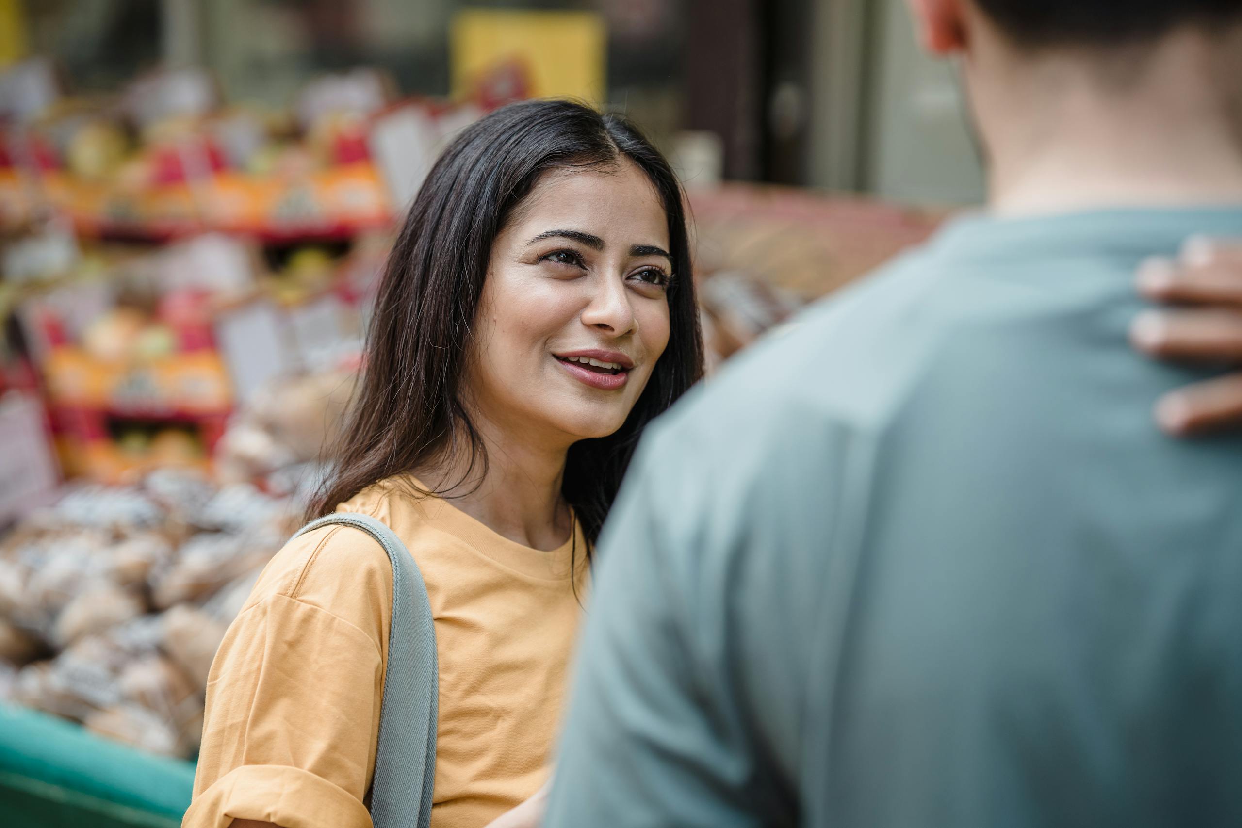 Smiling South Asian couple enjoying a day at the street market, engaging in conversation.