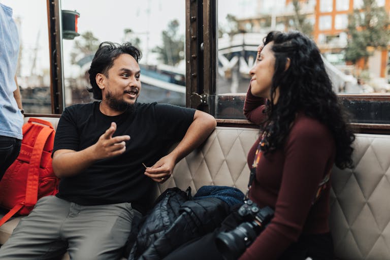 Two friends engaging in a relaxed conversation indoors, surrounded by modern decor.